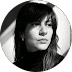 Retrato circular en blanco y negro de mujer joven con flequillo y cuello alto oscuro.